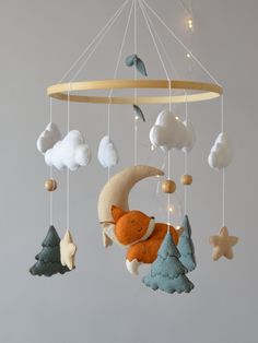 a mobile with a fox, moon and stars hanging from it