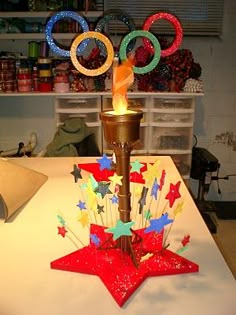 the olympic torch is lit up with colorful paper stars