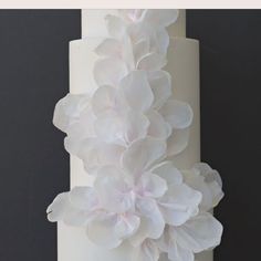 a white cake with flowers on top and the words, how to make a wafer paper flower cake