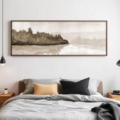 a bed sitting under a painting on top of a wall