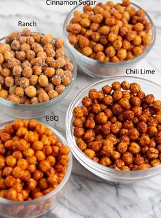 four bowls filled with different types of chickpeas on a marble countertop top