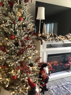 a decorated christmas tree in front of a fireplace