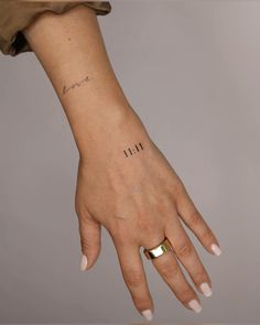 a woman's hand with a small tattoo on it