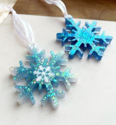 two snowflakes are hanging on a string