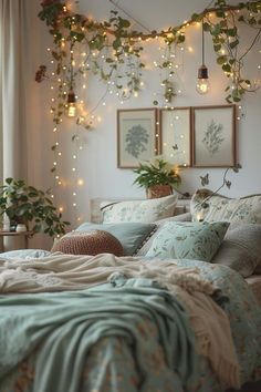 a bed covered in lots of pillows and blankets next to a window with lights on it