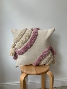 a pillow sitting on top of a wooden stool