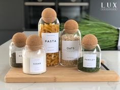 four glass jars filled with pasta and spices