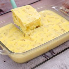 a container filled with yellow cake batter on top of a wooden table