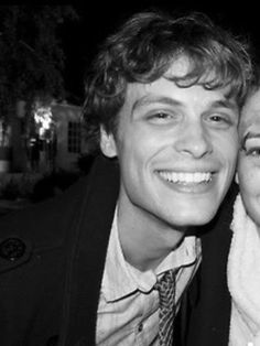 black and white photograph of two people smiling at the camera with their heads close to each other