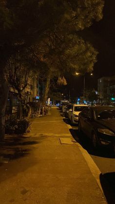 cars parked on the side of a street at night