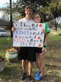 a man and woman standing next to each other holding a sign