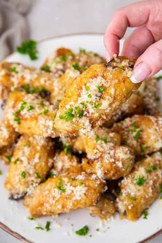 someone is dipping something into some food on a plate with parmesan sprinkles