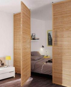 a bedroom with wooden slats on the walls and sliding doors open to reveal a bed