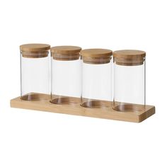 three glass jars with wooden lids on a shelf