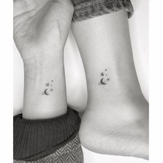 two people with matching tattoos on their feet, one is holding the other's hand