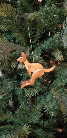 a wooden dog ornament hanging from a christmas tree