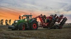 a tractor pulling a large load of equipment on it's back in a field