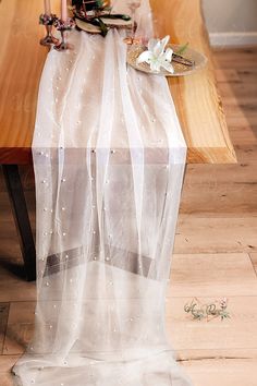 a table topped with a cake covered in white frosting next to candles and flowers