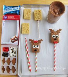 the tray is full of treats and candy sticks with reindeer faces on them, including marshmallows