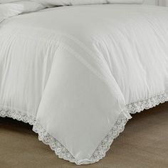 a bed with white sheets and pillows on top of it