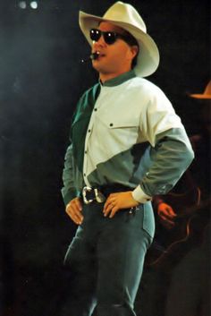 a man in a cowboy hat and sunglasses on stage