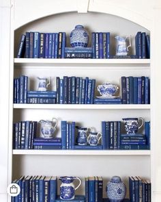 blue and white bookshelves with vases, cups and mugs on them