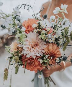 a woman holding a bouquet of flowers in her hands