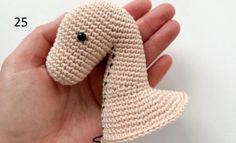 a hand holding a crocheted dog ornament