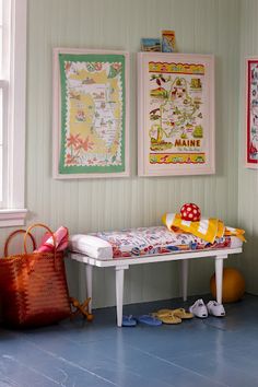 a child's room with two pictures on the wall and a small white bench