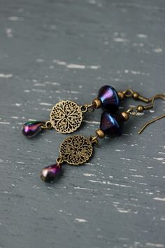 Unique boho earrings with antique brass round charms, bicone czech glass beads with blue-purple finish, multilocred czech glass drop beads with purple-green finish and antique brass earring hooks. Earring hooks are from nickel free and lead free metal. A wonderful jewelry for everyday wear and a great gift! The total lenght of earrings is about 71 mm including earring hooks. Other earrings of my shop you can see here: https://www.etsy.com/shop/NaTavelli?section_id=13757927 Thanks for visit. Metal Beaded Earrings With Pearl Drop As Gift, Pearl Drop Beaded Earrings As A Gift, Metal Pearl Earrings With Dangling Beads For Gift, Green Pearl Earrings, Modern Pearl Earrings, Brass Earring, Pearl Dangle Earrings, Long Drop Earrings, Earrings Elegant