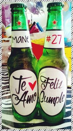 two green beer bottles with the words feliz cumple written on each bottle