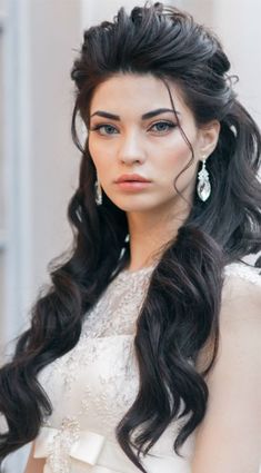 a woman with long black hair wearing a white dress