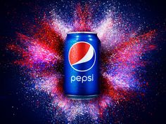 a can of pepsi with red and blue sprinkles around it on a dark background