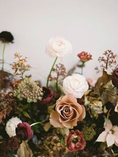 a vase filled with lots of flowers on top of a table