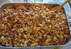 a casserole dish full of nuts and pecans with a wooden spoon in it