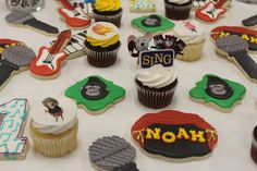 a table topped with lots of decorated cupcakes