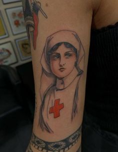 a woman with a red cross tattoo on her arm