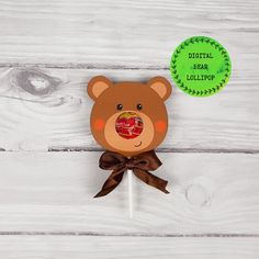 a teddy bear lollipop with a ribbon around it