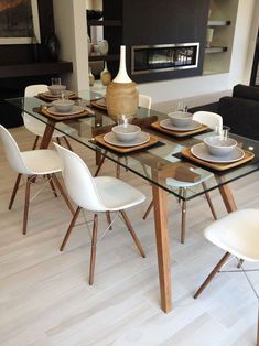 a glass table with white chairs around it