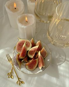 figs on a plate next to candles and wine glasses