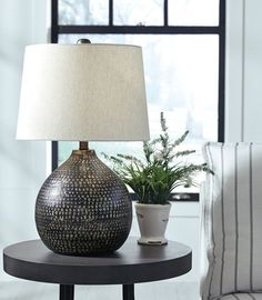 a table with a lamp and potted plant on it