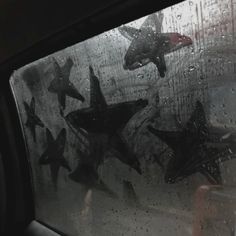 several airplanes are seen through the windshield of a car in the rain, while people stand nearby