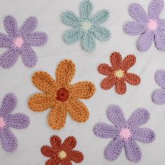 crocheted flowers are arranged on a white surface