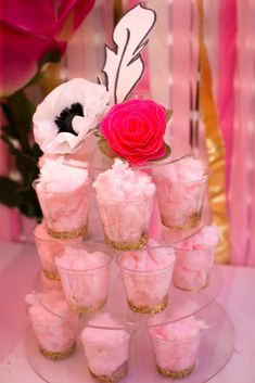 pink cupcakes are arranged on a cake stand with a rose in the middle