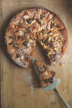 a pizza sitting on top of a wooden cutting board next to a slice missing from it