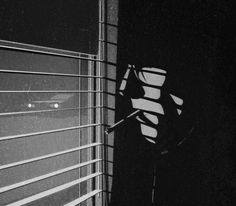 a black and white photo of a window with blinds drawn on it's side