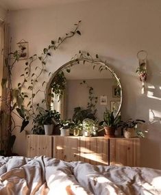 a bedroom with plants on the wall and a round mirror