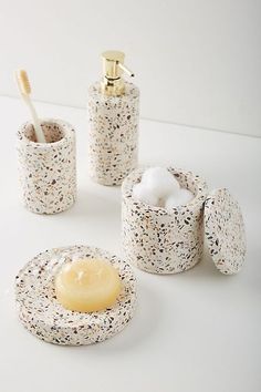 bathroom accessories including soap, toothbrush and other items on a white counter top with speckles