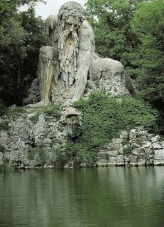 a statue of a man with a beard sitting next to a body of water