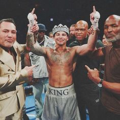 two men standing next to each other with their hands in the air while one man holds his fist up